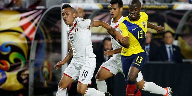 Peru's Christian Cueva dribbles the ball away from Ecuador's Enner Valencia on June 8, 2016, in Glendale, Ariz.
