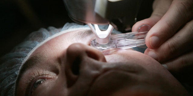 ** ADVANCE FOR SUNDAY, DEC. 11 **Dr. Colman Kraff docks the femtosecond laser, flattening the cornea, of patient Steve Parker as the initial step in creating the Lasik flap during Parker's eye surgery at Kraff's offices in Chicago Nov. 1, 2005. (AP Photo/Charles Rex Arbogast)
