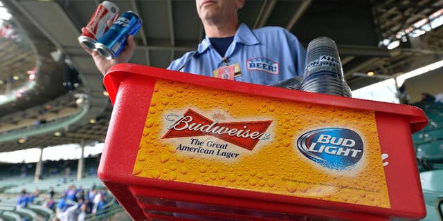 FILE - In this Tuesday, Oct. 13, 2015, file photo, a beer vender holds up Budweiser and Bud Light at Wrigley Field before Game 4 in baseball's National League Division Series between the Chicago Cubs and the St. Louis Cardinals in Chicago. Budweiser's owner Anheuser Busch InBev clinched a preliminary deal earlier this month to take over British beer company SABMiller for around 69 billion pounds ($106 billion). A survey from consulting firm EY on Monday, Oct. 26, 2015, points to more global mega-deals in the year to come. (AP Photo/Paul Beaty, File)