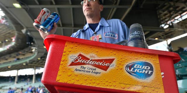 FILE - In this Tuesday, Oct. 13, 2015, file photo, a beer vender holds up Budweiser and Bud Light at Wrigley Field before Game 4 in baseball's National League Division Series between the Chicago Cubs and the St. Louis Cardinals in Chicago. Budweiser's owner Anheuser Busch InBev clinched a preliminary deal earlier this month to take over British beer company SABMiller for around 69 billion pounds ($106 billion). A survey from consulting firm EY on Monday, Oct. 26, 2015, points to more global mega-deals in the year to come. (AP Photo/Paul Beaty, File)