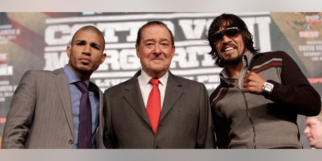 Boxers Miguel Cotto, left, of Puerto Rico, and Antonio Margarito, right, of Mexico, flank promoter Bob Arum during a news conference Wednesday, Nov. 30, 2011 at Madison Square Garden in New York. Cotto will defend his WBA Super World junior middleweight title against Margarito on Saturday, Dec. 3, in New York. (AP Photo/Mary Altaffer)