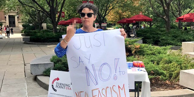 University of Nebraska graduate student Courtney Lawton protesting in front of a recruitment table for the conservative student group Turning Point USA.