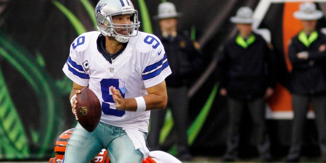 Dallas Cowboys quarterback Tony Romo (9) avoids a sack by Cincinnati Bengals defensive tackle Domata Peko (94) in the second half of an NFL football game, Sunday, Dec. 9, 2012, in Cincinnati. Dallas won 20-19. (AP Photo/Tom Uhlman)