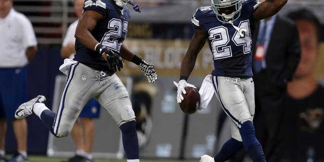 Dallas Cowboys cornerback Morris Claiborne, right, celebrates after intercepting a pass as teammate strong safety J.J. Wilcox watches during the fourth quarter of an NFL football game against the St. Louis Rams, Sunday, Sept. 21, 2014, in St. Louis. The Cowboys won 34-31. (AP Photo/Jeff Roberson)