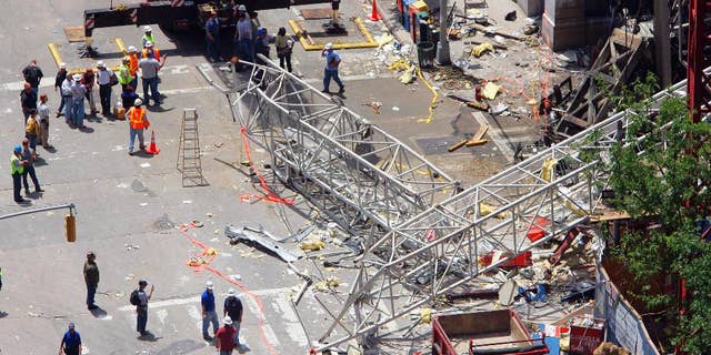 FILE - In this May 30, 2008 file photo, crews work at the scene of a crane collapse on the Upper East Side of New York. The New York City construction crane owner who was acquitted of manslaughter in a collapse that killed two workers has gone on trial again in a civil wrongful death case. Lawyers for the slain workers' families gave opening statements on Friday, May 23, 2014 in the trial of James Lomma, his company and others involved in the accident. (AP Photo/Stephen Chernin, File)
