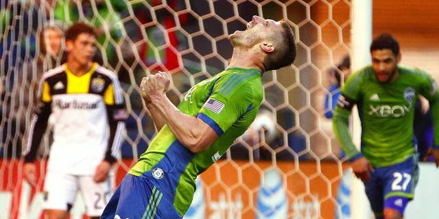 Seattle Sounders midfielder Kenny Cooper celebrates after scoring against Columbus Crew goalkeeper Steve Clark in the first half od an MLS soccer game on Saturday, March 29, 2014, in Seattle, Wash. (AP Photo/The Seattle Times, John Lok) MANDATORY CREDIT TO BOTH THE SEATTLE TIMES AND THE PHOTOGRAPHER; SEATTLE OUT; USA TODAY OUT; MAGAZINES OUT; TV OUT, NO SALES