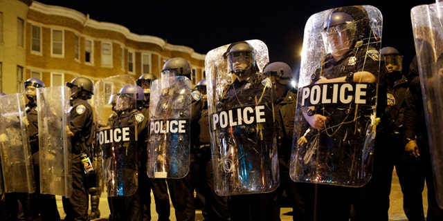FILE - In this April 28, 2015 file photo, police stand in formation as a curfew approache in Baltimore, a day after unrest that occurred following Freddie Gray's funeral. (AP Photo/Patrick Semansky, File)