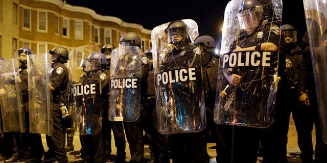 FILE - In this April 28, 2015 file photo, police stand in formation as a curfew approache in Baltimore, a day after unrest that occurred following Freddie Gray's funeral. (AP Photo/Patrick Semansky, File)