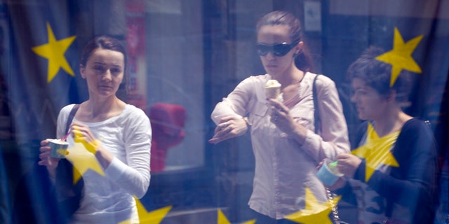 June 30, 2013: A street scene is reflected in the window of a library with an EU flag on display in downtown Zagreb, Croatia.