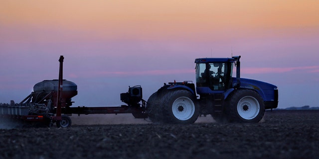 In this Saturday, June 8, 2013 photo, a central Illinois farmer continues planting corn seed into the evening in Farmingdale, Ill.