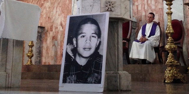 FILE - In this Oct. 14, 2014, file photo, a photo of Jose Antonio Elena Rodriguez, who was fatally shot by U.S. Border Patrol near the Mexico-U.S border, leans against a podium on a church altar during a memorial mass in Nogales, Sonora, Mexico. The civil rights case against Agent Lonnie Swartz over the Rodriguez' death will go forward after U.S. District Court Judge Raner C. Collins denied a part of his motion to dismiss the case. (AP Photo/Valeria Fernandez, File)