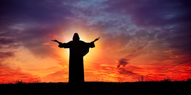 Man praying at sunset