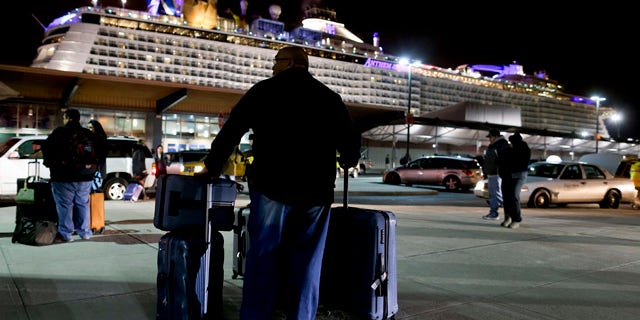 Feb. 10, 2016: A passenger from the Royal Caribbean cruise ship, Anthem of the Seas, awaits transportation after arriving at Cape Liberty cruise port in Bayonne, N.J. (AP Photo/Julie Jacobson)