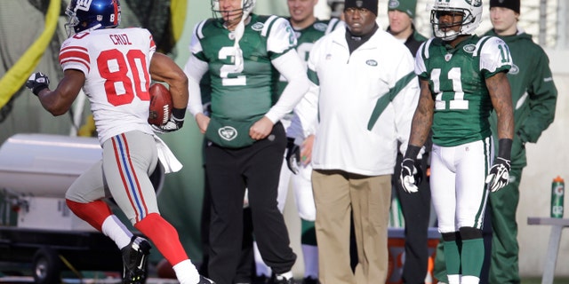 New York Giants' Victor Cruz (80) runs 99 yards for a touchdown as the New York Jets sideline watches during the second quarter of an NFL football game between the New York Giants and the New York Jets, Saturday, Dec. 24, 2011, in East Rutherford, N.J. (AP Photo/Julio Cortez)