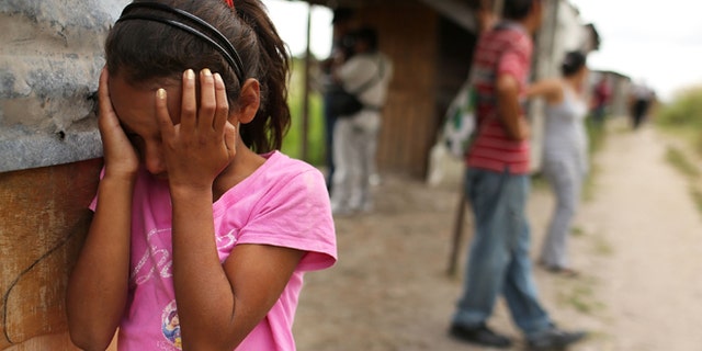 TEGUCIGALPA, HONDURAS - JULY 20: A young girl cries as her home and neighborhood are forcefully dismantled in a shanty town after the government claimed that the settlement was illegal on July 20, 2012 in Tegucigalpa, Honduras. Land disputes are becoming increasingly frequent in Honduras which is alarming the nation's business class while sowing fears of increased political violence. In a nation where 72% of the poorest landowners hold only 11.6% of cultivated land, tensions are rising as the poor have few places to go and little opportunities for productive employment. Honduras now has the highest per capita murder rate in the world and its capital city, Tegucigalpa, is plagued by violence, poverty, homelessness and sexual assaults. With an estimated 80% of the cocaine entering the United States now being trans-shipped through Honduras, the violence on the streets is a spillover from the ramped rise in narco-trafficking. (Photo by Spencer Platt/Getty Images)