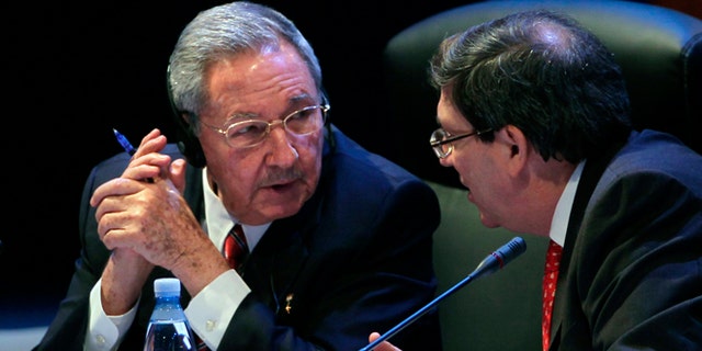 Cuba's President Raul Castro speaks to his Foreign Minister Bruno Rodriguez during a session of the CELAC Summit in Havana, Cuba, Tuesday, Jan. 28, 2014. Leaders from Latin America and the Caribbean are in Cuba to talk about poverty, inequality and hunger at the summit of the Community of Latin American and Caribbean States, or CELAC. (AP Photo/Cubadebate, Ismael Francisco)