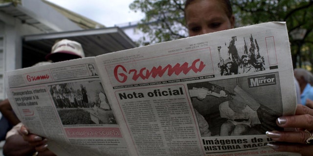 HAVANA, CUBA - MAY 11: A woman reads the official newspaper of the Cuban Communist Party May 11, 2004 in Havana, Cuba. President Fidel Castro's government announced the suspension of most goods bought with US dollars. Castro blamed the new measure on the Bush Administration's decision last week to tighten trips and cash remittances to the island. (Photo by Jorge Rey/Getty Images)