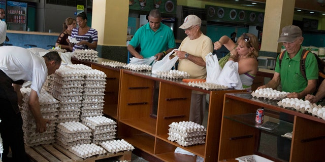 People buy eggs at a a store in Havana, Cuba, Friday, March 20, 2015. More than a dozen Cuban officials have been sentenced to between five and 15 years in prison in connection with what authorities call a scheme to divert millions of eggs to the black market. (AP Photo/Desmond Boylan)