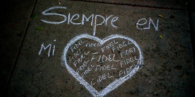 A heart and the text that reads in Spanish "Always in my heart Fidel" are outlined in chalk on a sidewalk, during a vigil at the university where the late Cuban leader Fidel Castro studied law as a young man in Havana, Cuba, Saturday, Nov. 26, 2016. Castro, who led a rebel army to improbable victory in Cuba, embraced Soviet-style communism and defied the power of U.S. presidents during his half century rule, died at age 90. (AP Photo/Ramon Espinosa)