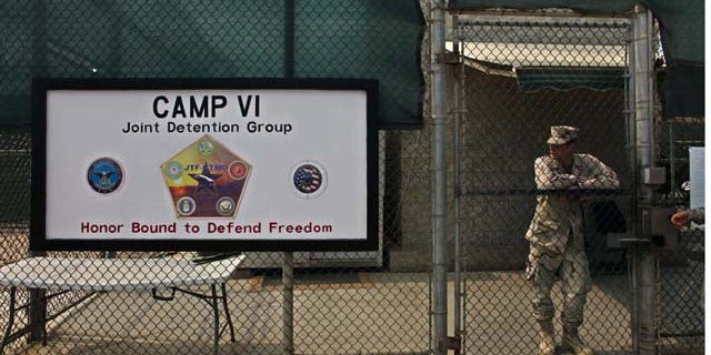 In this file photo taken Tuesday May 12, 2009 and reviewed by the U.S. military, a soldier stands guard at the front gate entrance to the Camp 6 maximum-security detention facility, at Guantanamo Bay U.S. Naval Base, Cuba. (AP)