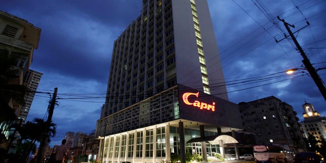 The hotel Capri is illuminated at dawn in Havana, Cuba, Friday, Feb. 14, 2014. Havana's hedonistic mob-and-movie-star days came to an end with Fidel Castro's 1959 revolution, and the hotel drifted into a long, slow decline. But now the Capri is back in business after being closed more than a decade ago. Its rebirth is part of Cuba's latest bid to trade on its colorful pre-Communist past and attract tourist dollars to fund its socialist present. (AP Photo/Franklin Reyes)
