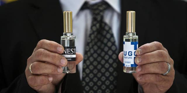A man shows two bottles of cologne, one called "Ernesto," honors guerrilla leader Ernesto "Che" Guevara, and "Hugo," for the late Venezuelan president Hugo Chavez, in Havana, Cuba, Wednesday, Sept. 24, 2014. Formulated by a French company and produced in Cuba, the colognes are being presented this week at a Labiofam convention in Havana. (AP Photo/Franklin Reyes)