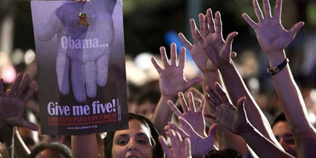 A woman holds a poster that reads "Obama give me five" during a concert in honor of the five intelligence agents in Havana, Cuba, Saturday, March 1, 2014. Thousands of Cubans rallied at the University of Havana on Saturday night for a concert to give a hero's welcome to the second of five intelligence agents to return to the island after completing long prison terms in the United States. (AP Photo/Franklin Reyes)