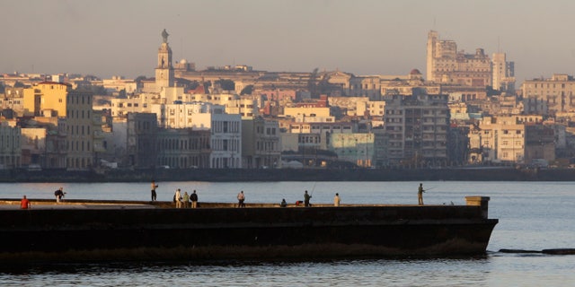 People fish from a dock in Havana Bay, Cuba, Tuesday Feb. 7, 2012. (AP Photo/Franklin Reyes)