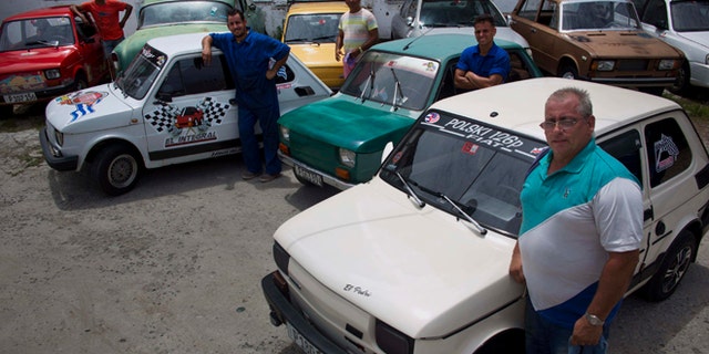 Fiat Polski 126p, owners Raul Seoane, left, Ramses Fernandez, second left, Evilio Aguilar, center, Rigoberto Mesa, second right, and Pedro Fernandez, proudly pose with their cars in Havana, Cuba, Tuesday, August 10, 2016. With around just 24 horsepower, depending on exactly how each one has been altered, the half-ton Polski offers families a shot at independent mobility for a few thousand dollars, a sum within reach of those able to save from private jobs or family sending money from overseas. (AP Photo/Ramon Espinosa)