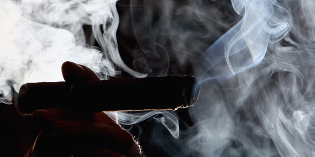 GLASGOW, UNITED KINGDOM - MARCH 20: A man is seen smoking in a cigar shop March 20, 2006, in Glasgow, Scotland. Smoking in public places in Scotland will be banned from the morning of March 26, 2006. (Photo by Jeff J Mitchell/Getty Images)