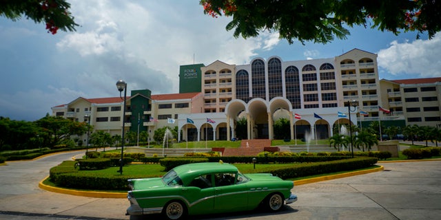 A vintage car passes in front of the Four Points by Sheraton hotel in Havana, Tuesday, June 28, 2016.