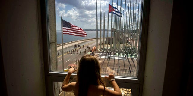 FILE - In this Aug. 14, 2015 file photo, a girl looks out from the newly opened U.S. Embassy after the U.S. flag raising ceremony in Havana, Cuba, as part of officially restored diplomatic relations. U.S. presidential candidate Donald Trump had been generally supportive of the normalization of relations with Cuba, but on Friday, Sept. 16, 2016 the Republican nominee pledged to reverse Obamaââ¬â¢s series of executive orders unless Cuba's President Raul Castro meets demands including ââ¬Åreligious and political freedom for the Cuban people and the freeing of political prisoners." (AP Photo/Ramon Espinosa, File)