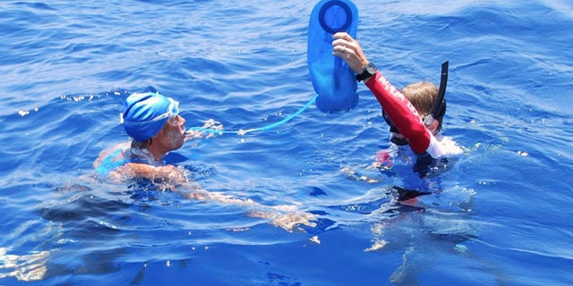 Aug. 20, 2012: In this photo provided by Diana Nyad via the Florida Keys News Bureau, endurance swimmer Diana Nyad is hydrated by a crew member in the Florida Straits between Cuba and the Florida Keys Monday.