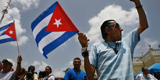 MIAMI - AUGUST 1: Angel Febles (R) of Miami Beach, Florida, waves a Cuban flag and shouts "Viva Cuba libre" in front of Versallies Restaurant in the Little Havana neighborhood August 1, 2006 in Miami, Florida. Febles immigrated to the U.S. from Cuba in 1960. Cuban Americans were celebrating the news that Fidel Castro had turned over power to his younger brother, Raul Castro, while he undergoes medical treatment for intestinal bleeding. (Photo by Chip Somodevilla/Getty Images)