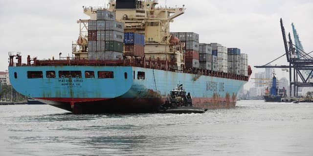 In this Friday, May 16, 2014 photo, a Maersk Line vessel is guided by a tugboat as it heads into the Port of Miami off of Miami Beach, Fla.  The Commerce Department reports on the U.S. current account trade deficit for the April-June quarter on Wednesday, Sept. 17, 2014. (AP Photo/Lynne Sladky)