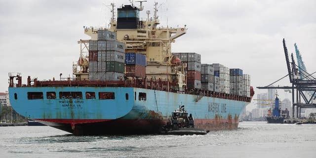 In this Friday, May 16, 2014 photo, a Maersk Line vessel is guided by a tugboat as it heads into the Port of Miami off of Miami Beach, Fla. The Commerce Department reports on the U.S. current account trade deficit for the April-June quarter on Wednesday, Sept. 17, 2014. (AP Photo/Lynne Sladky)