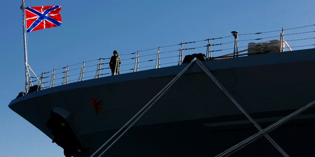 A Russian sailor stands guard on the Russian war ship "Peter the Great" in southern port city of Limassol, Cyprus, on Wednesday, Feb. 12, 2014. The Russian missile cruiser "Peter the Great" which is currently deployed in the region made a port of call at Cyprus' largest port. (AP Photo/Petros Karadjias)