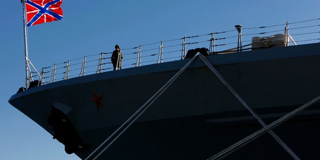 A Russian sailor stands guard on the Russian war ship "Peter the Great" in southern port city of Limassol, Cyprus, on Wednesday, Feb. 12, 2014. The Russian missile cruiser "Peter the Great" which is currently deployed in the region made a port of call at Cyprus' largest port. (AP Photo/Petros Karadjias)
