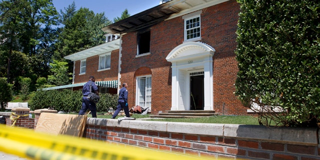 Police continue working at a fire-damaged multimillion-dollar home in northwest Washington home, Friday May 22, 2015, where 46-year-old Savvas Savopoulos, his 47-year-old wife, Amy Savopoulos, the couple's 10-year-old son Philip, and housekeeper Veralicia Figueroa were found dead May 14. U.S. marshals and police arrested a dangerous ex-convict and took his five companions into custody, safely ending a multistate manhunt in the slayings of a wealthy Washington family and their housekeeper. The fugitive task force tracked Daron Dylon Wint to New York and back before they caught up with him late Thursday (AP Photo/Jacquelyn Martin)