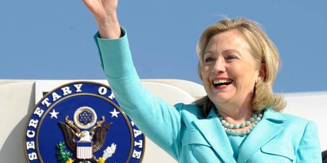 FILE - In this June 10, 2011, file photo, then-Secretary of State Hillary Rodham Clinton waves as the arrives at Lusaka International Airport in Lusaka, Zambia. Clinton confidantes view her four years at the helm of the State Department as her golden era _ a chance for one of the country’s most polarizing figures to jump off the political treadmill. She set a record for international travel and prioritized issues she had long been passionate about, including global health and boosting opportunities for women and girls. (AP Photo/Susan Walsh, Pool, File)