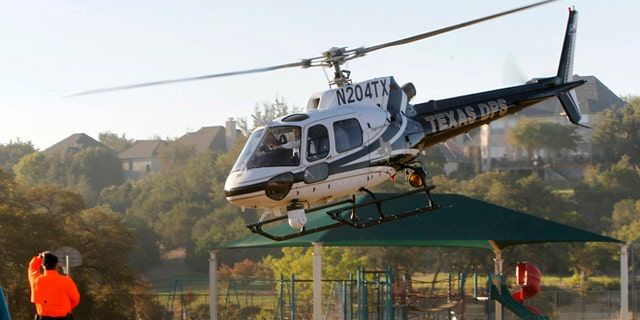 AUSTIN, TX - SEPTEMBER 6: Republican presidential candidate and Texas Gov. Rick Perry takes off aboard a Texas Department of Public Safety helicopter for an aerial tour of the area around Steiner Ranch where homes were destroyed by wildfires the last two days September 6, 2011 in Austin, Texas. Perry, who left his presidential campaign to respond to the fires, said more than 1,000 houses in the area were destroyed. (Photo by Erich Schlegel/Getty Images)