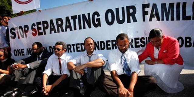 July 26: Supporters of the DREAM Act, including Rep. Luis Gutierrez, D-Ill., third from right, wait to be arrested while performing an act of civil disobedience at a rally for supporting the DREAM Act and immigration reform outside the White House in Washington, D.C.