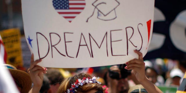 FILE: May 1, 2013: A Dream Act supporter carries a sign during the International Workers Day and Immigration Reform March in Los Angeles, Calif.