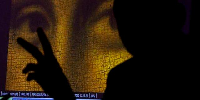This 2011 file photo shows art historian and researcher Silvano Vinceti, silhouetted, gesturing as an image showing the detail of the eyes of Italian artist Leonardo da Vinci's "Mona Lisa" painting is projected.