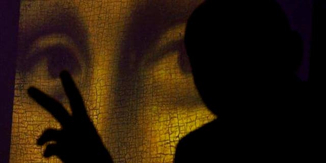 This 2011 file photo shows art historian and researcher Silvano Vinceti, silhouetted, gesturing as an image showing the detail of the eyes of Italian artist Leonardo da Vinci's "Mona Lisa" painting is projected.