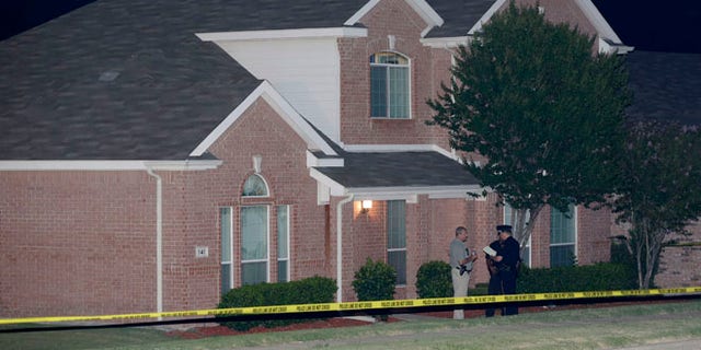 Aug. 8: Law enforcement officers confer outside the house of a fatal shooting in DeSoto, Texas.