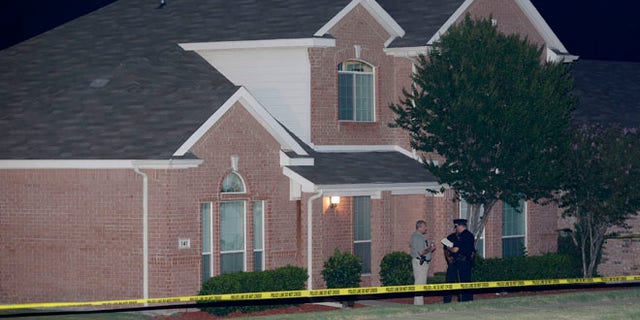 Aug. 8: Law enforcement officers confer outside the house of a fatal shooting in DeSoto, Texas.