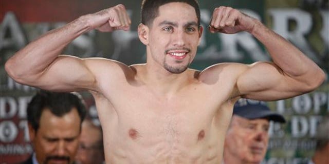Unified Super Lightweight World Champion Danny "Swift" Garcia poses for photos as he makes weight during the official weigh-in at the Ruben Rodriguez Coliseum in Bayamon, Puerto Rico, Friday, March 14, 2014. Garcia will defend his title against Mauricio "El Maestro" Herrera on Showtime Championship Boxing's main event Saturday. (AP Photo/Ricardo Arduengo)