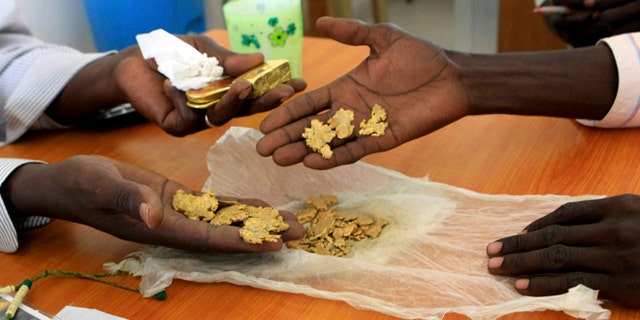 September 24, 2013: Gold mine workers wait to get their raw gold weighed at a gold shop in the town of Al-Fahir in North Darfur.