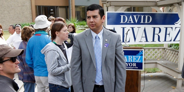 David Alvarez, above center, a San Diego city councilman and Democratic candidate for mayor, looks on as he meets with supporters Tuesday, Nov. 19, 2013, in San Diego. San Diegans head to the polls Tuesday to choose a new mayor, after Bob Filner's resignation amid allegations of sexual harassment has left the city with an interim mayor. (AP Photo/Gregory Bull)